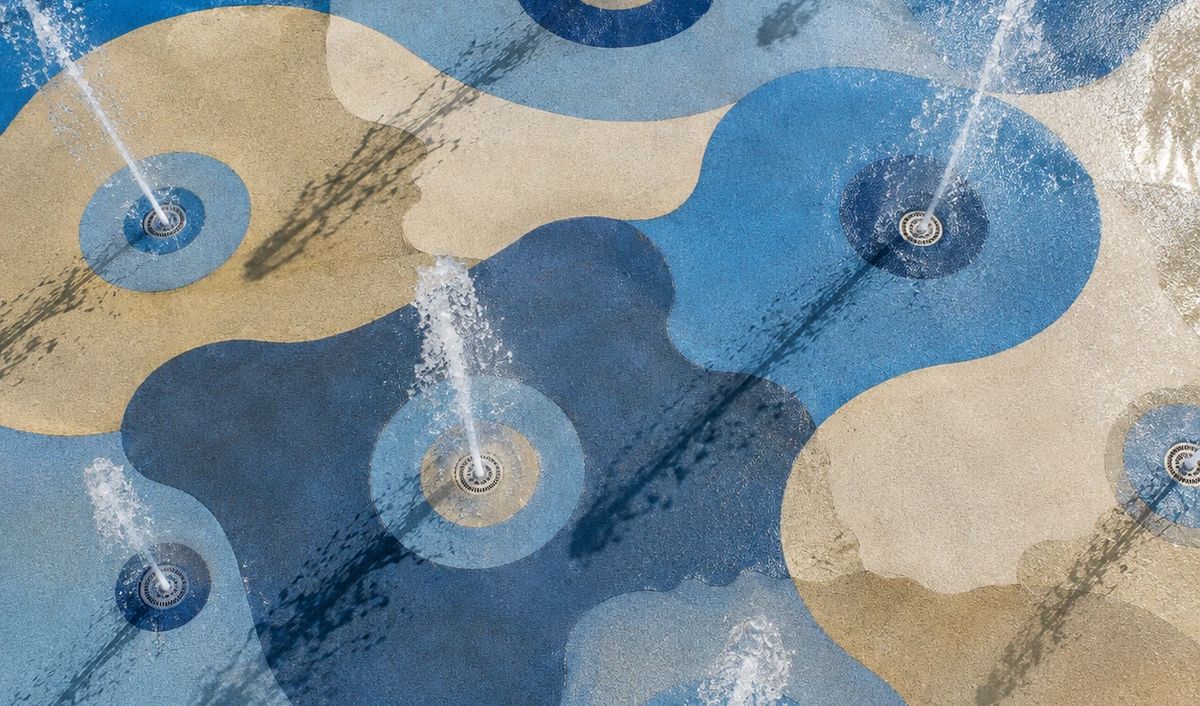 Overhead view of a splash pad deck with ground jets throwing vertical water columns